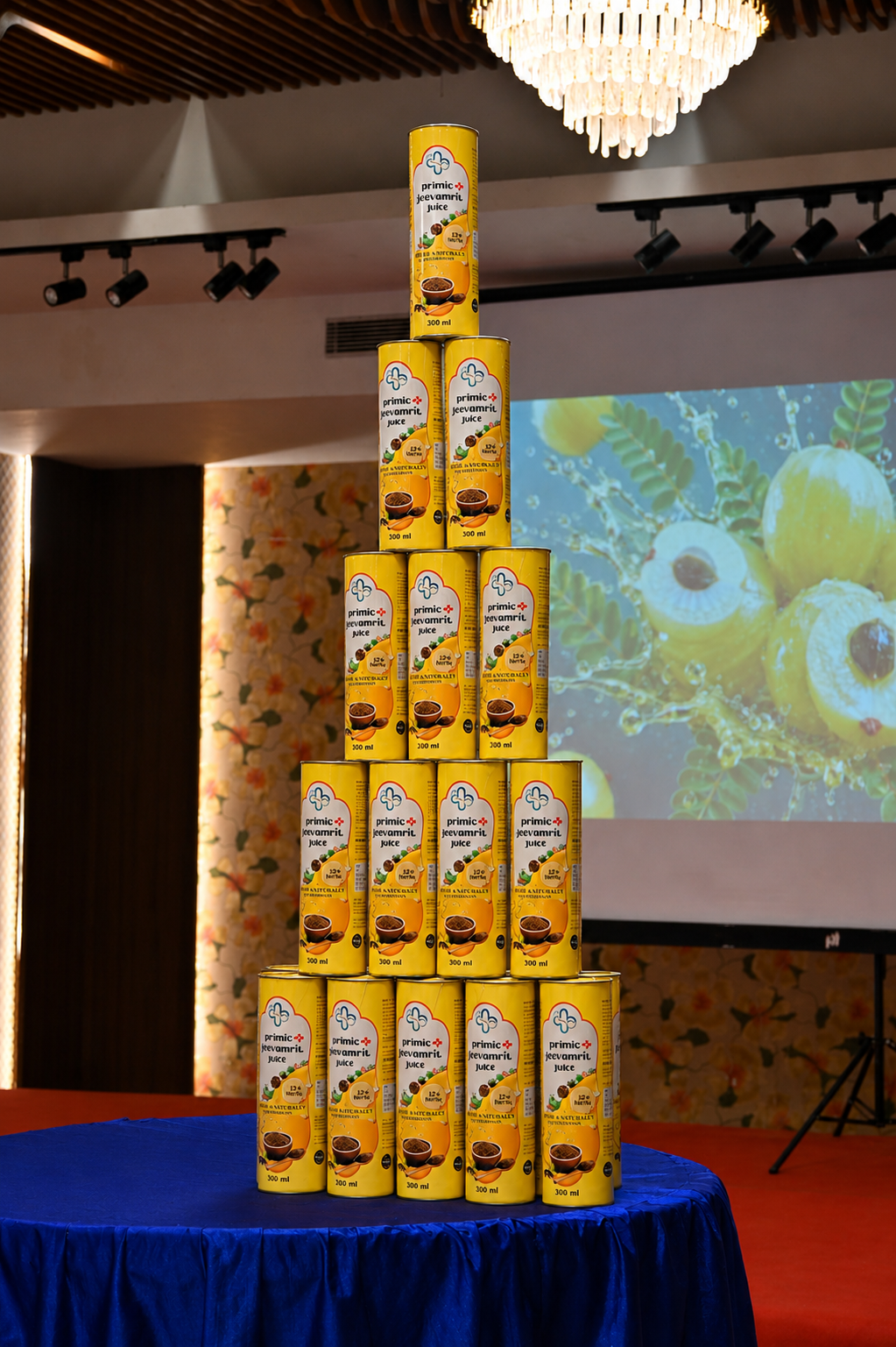 Primic Jeevamrit Juice launch event featuring a speaker presenting the Jeevamrit Juice bottle on stage